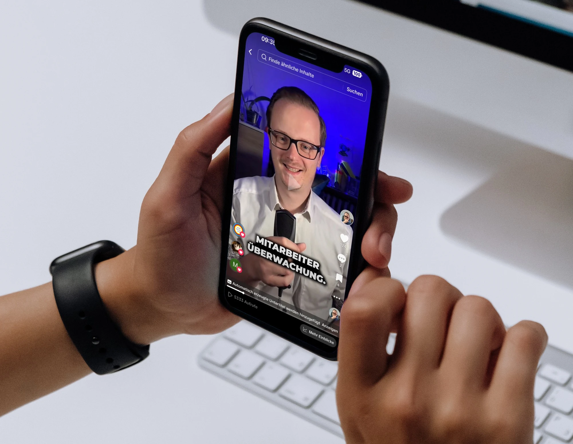 A hand holding a phone, with a social mdeia video on it