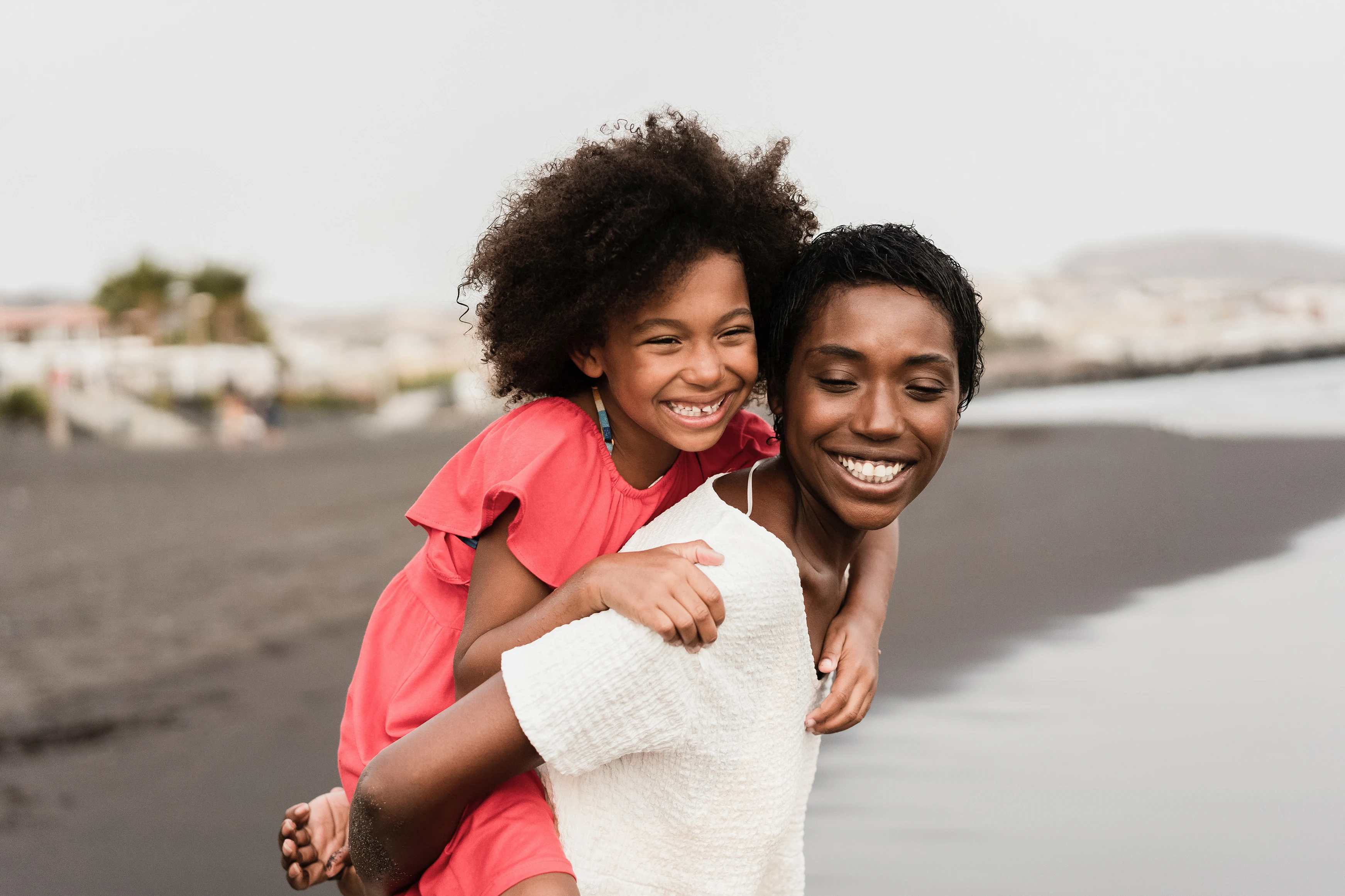 r61-black-mother-and-daughter-running-on-the-beach-during-holiday-vacations-focus-on-17267792978855.jpg